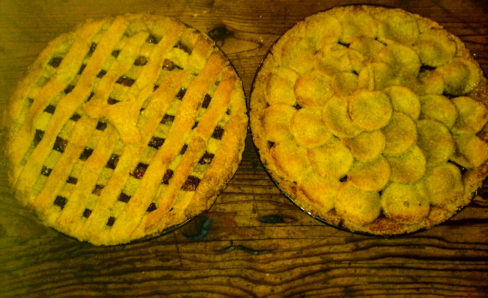 two cherry pies sitting on the bench