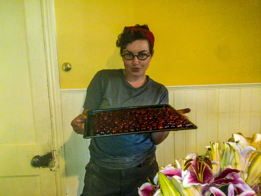 Kirsten (aka Rosie the Riveter) with a tray of pitted cherries about to go in the oven to dry