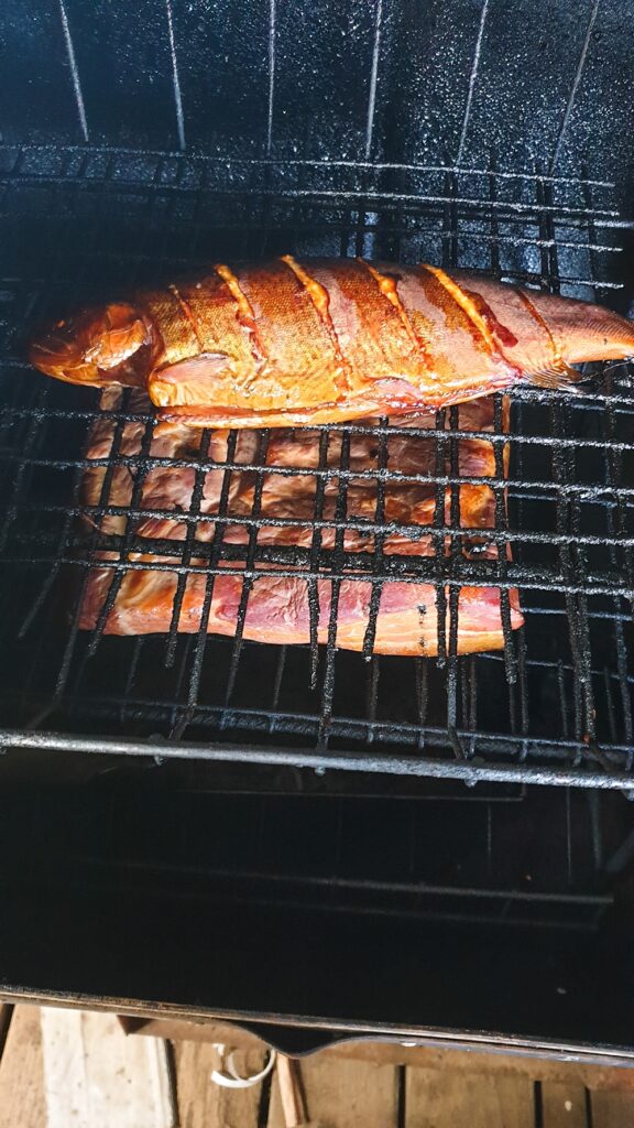 Fish and home-cured bacon smoking in the smoker